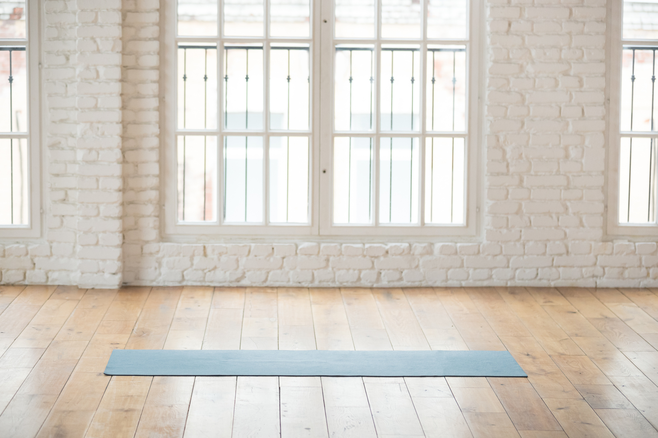 Unrolled yoga mat in empty fitness studio
